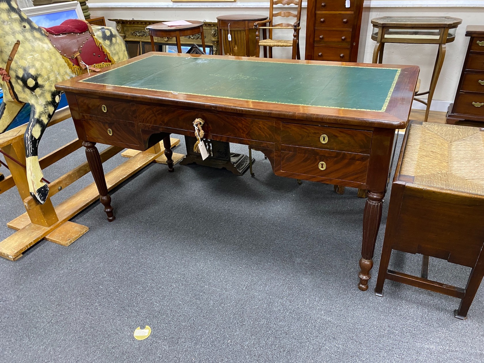 An early 20th century French mahogany kneehole writing table on fluted legs width 144cm, depth 71cm, height 76cm.